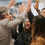 Group celebrates success with high fives, feeling joyful and accomplished